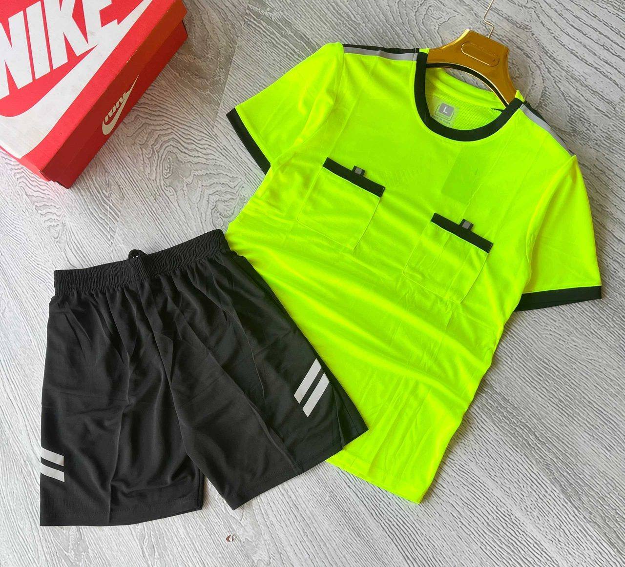 A neon yellow sports jersey with black trim and matching black shorts, unbranded and ready for team logos