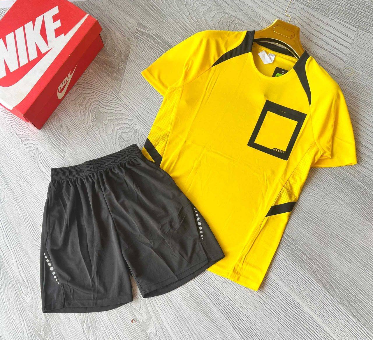 A yellow sports jersey with black trim and matching black shorts, unbranded and ready for team logos